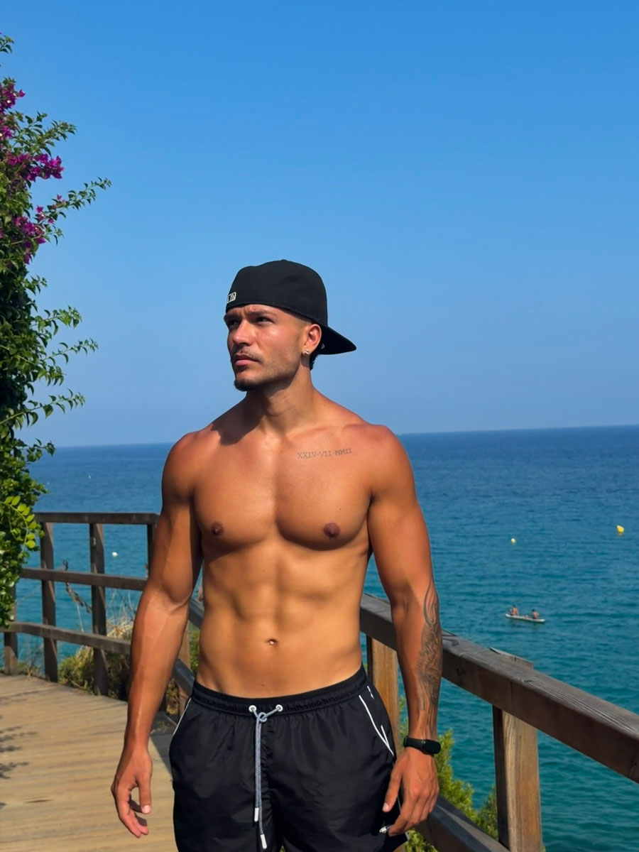 El entrenador está posando cerca de la playa.